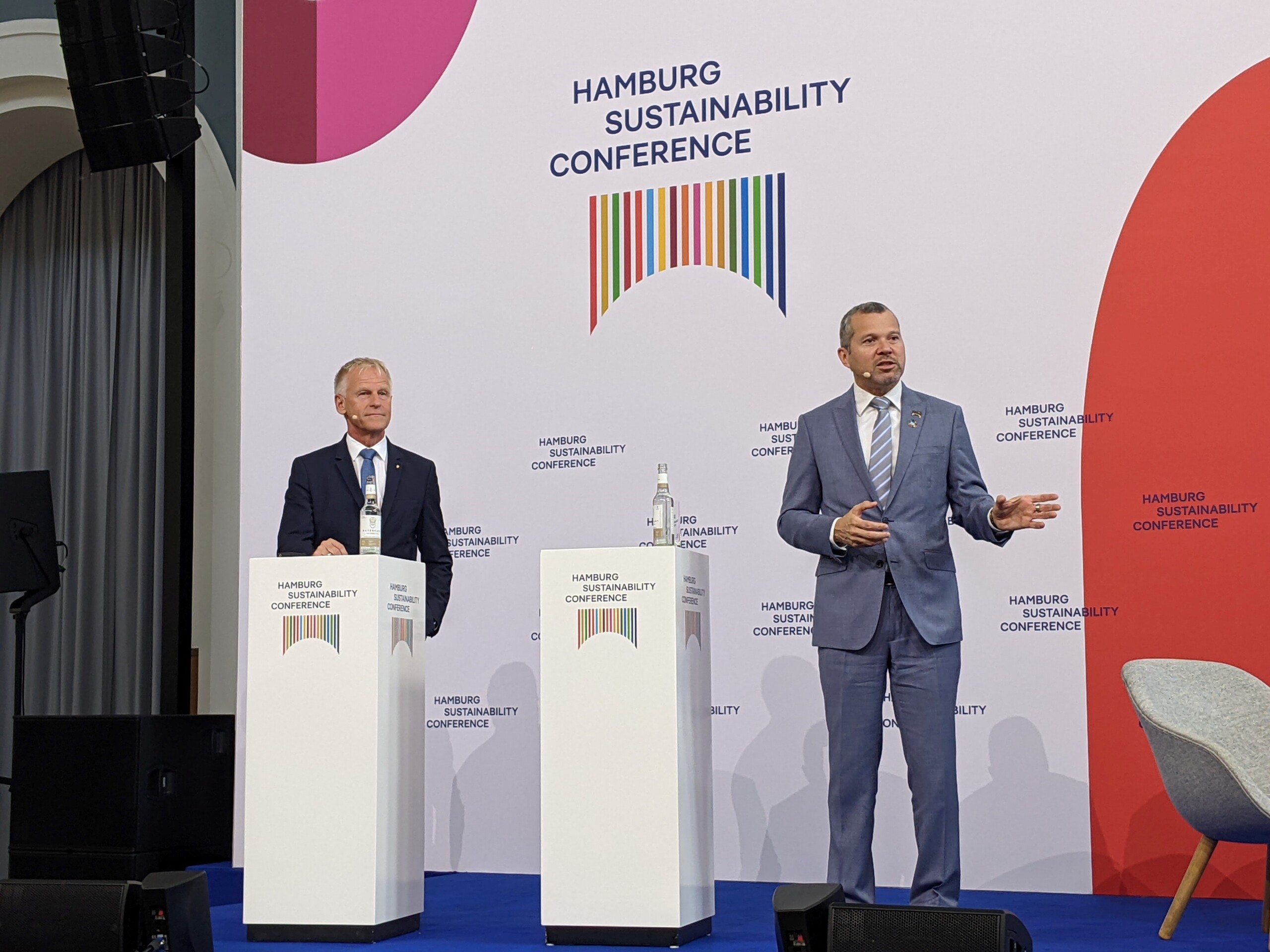 Jens Meier, Vorsitzender der Geschäftsführung der Hamburg Port Authority, und Arsenio Dominguez, Generalsekretär International Maritime Organisation, stehen auf der Bühne